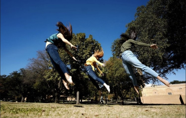 People jumping in the air on UNT campus