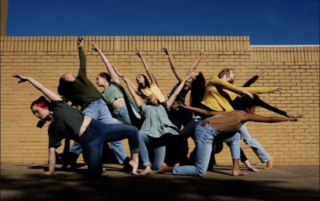 People posing outside of a building. 