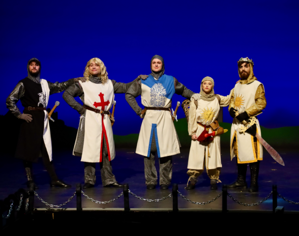 Five actors as knights standing on stage 